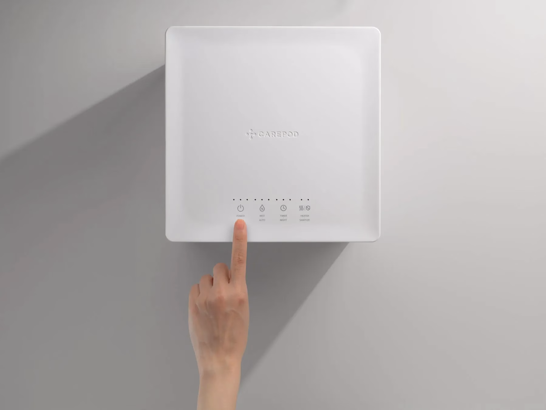 白いデバイスに手が触れている様子