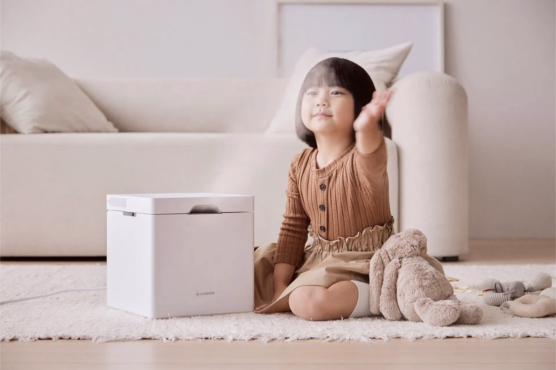 小さな女の子が加湿器のそばに座っている画像