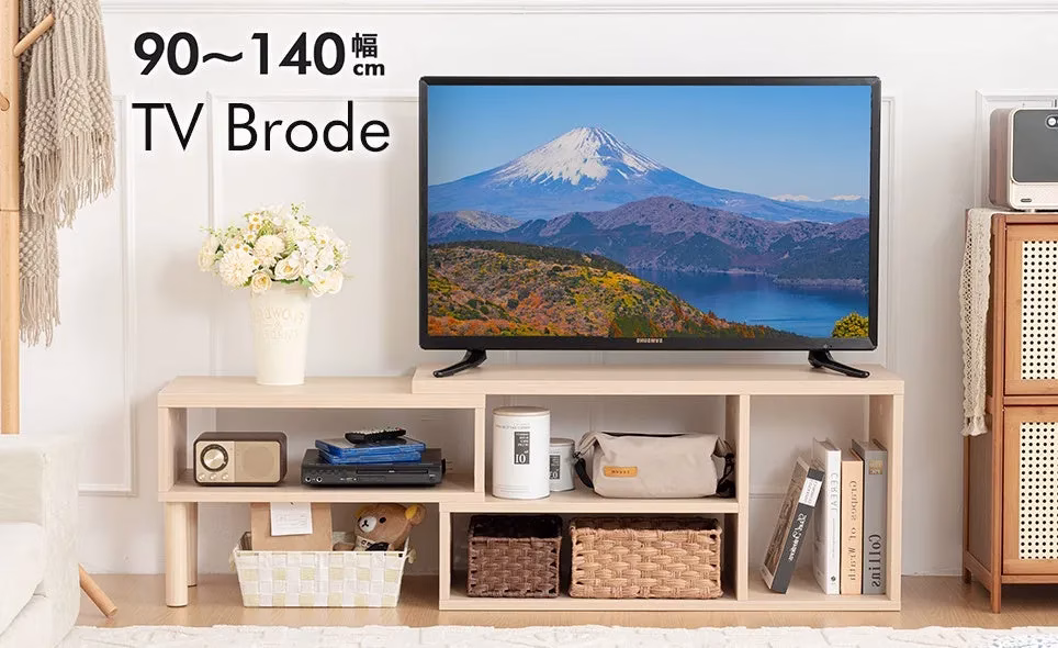 テレビ台の上にテレビが置かれており、その周りには装飾品や収納スペースがあります。背景には白い壁があり、全体的に明るく清潔感のある印象を与えます。