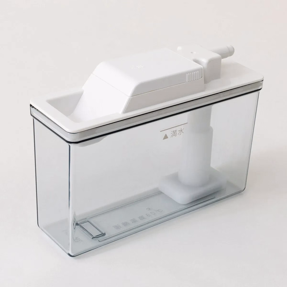 透明な容器に白い蓋と内部構造が組み込まれた製品の写真。蓋には注入口のような突起があり、「満水」の文字とマークが見える。製品の側面には「耐熱温度60℃」と記載。