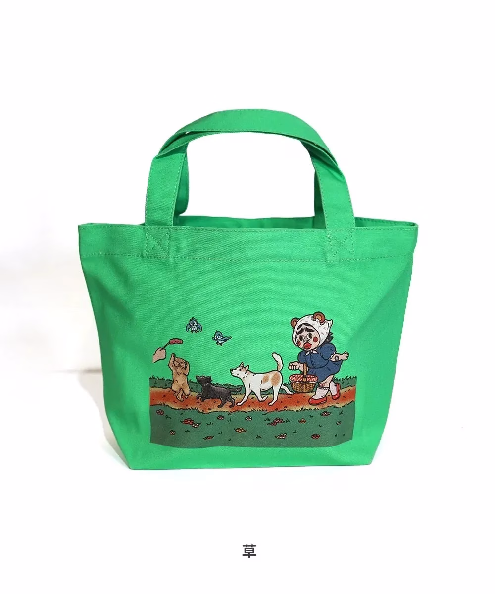 緑色のトートバッグ。イラストには、バスケットを持った人物と犬、草むらが描かれている。