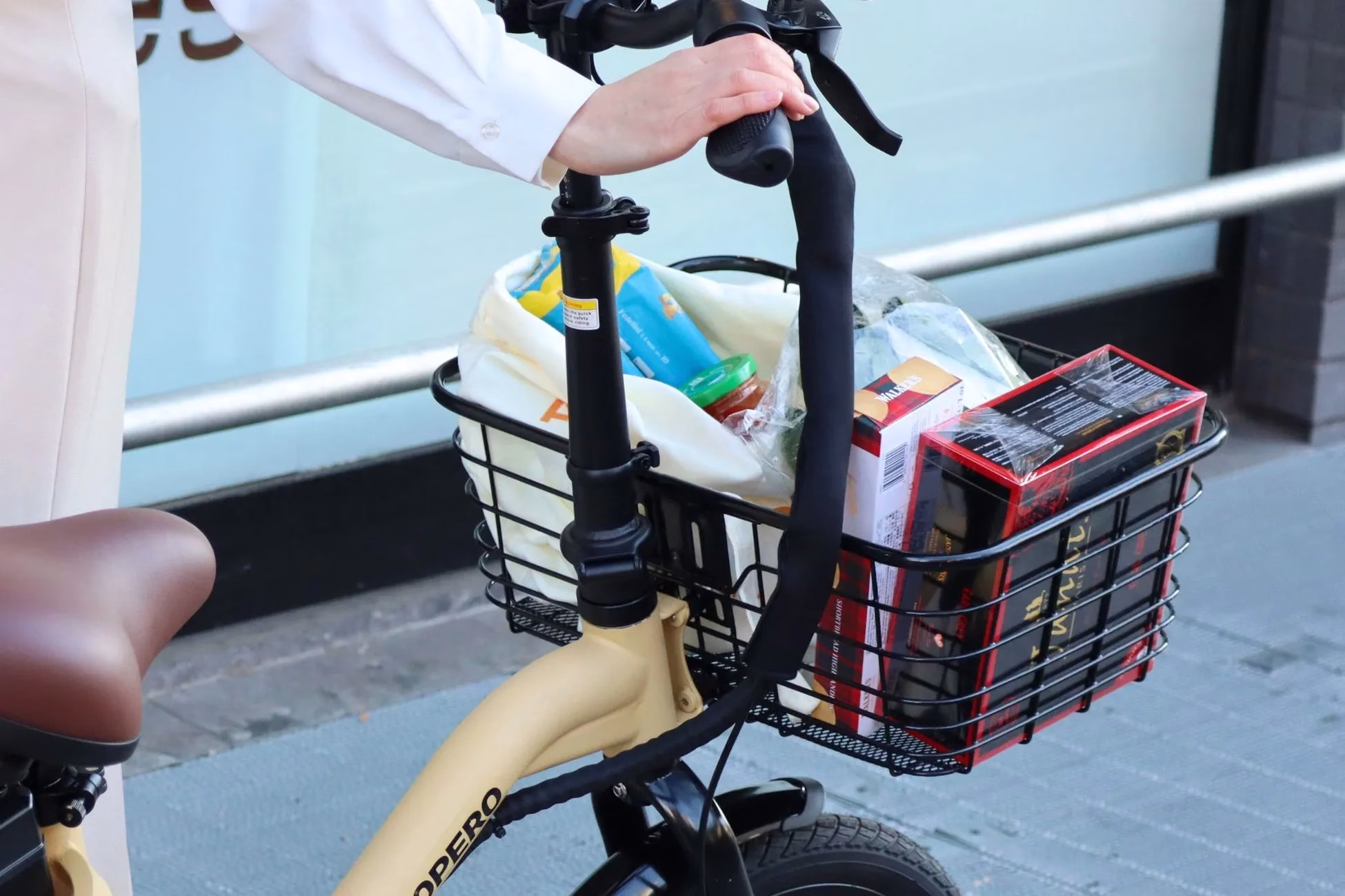 カゴに食料品を入れた自転車に乗る人