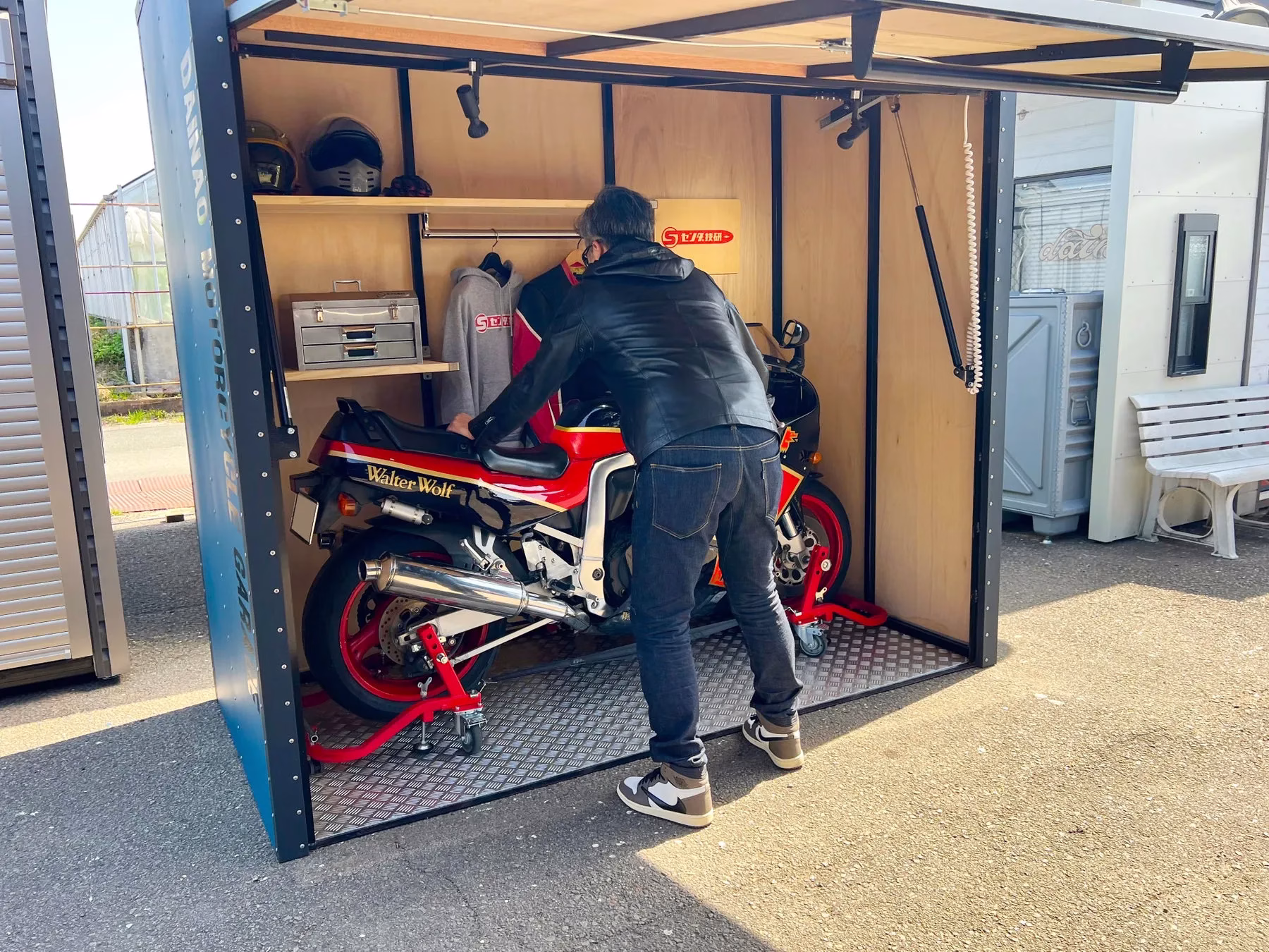 バイクが格納された小屋にいる男性