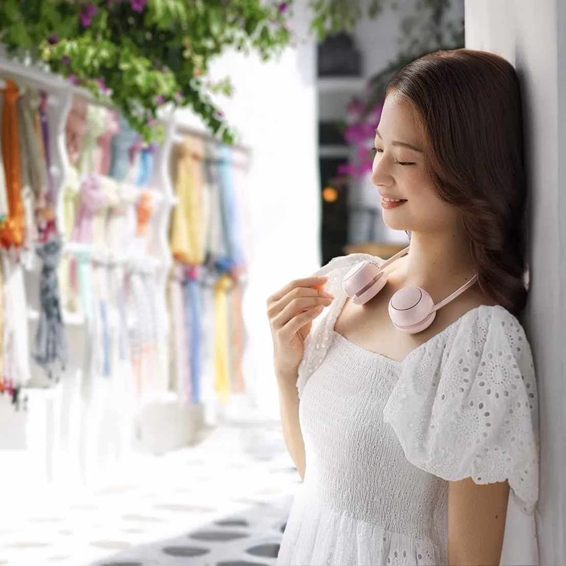 女性が首掛け扇風機をしている