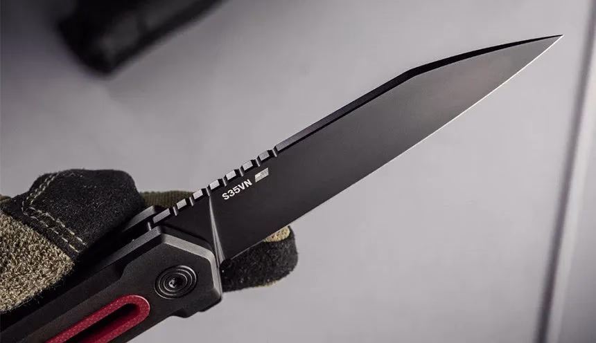 黒い刃物と黒い手袋をした手のクローズアップ写真