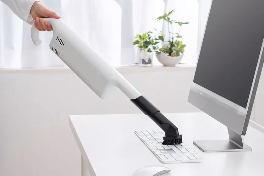 キーボードを掃除機で掃除している様子。