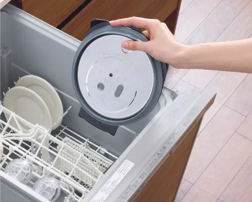 食器洗い機から取り外された蓋を持つ手。
